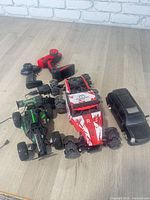 All three RC cars and two remotes on floor
