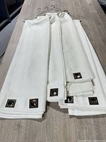 Four white grommet curtain panels folded on table