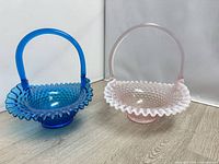 Full view of both Fenton hobnail glass baskets side by side