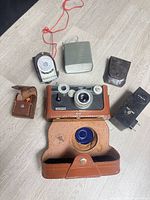 Group shot showing camera, light meter, flash units and accessory cases