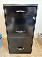 Front view showing three drawers and lock with key