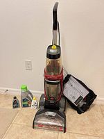 Full view of carpet cleaner, accessory bag, and cleaning solutions