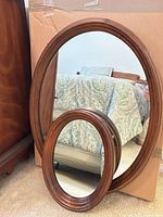 Both Ethan Allen oval mirrors leaning together