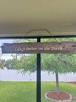 Full view of driftwood sign showing complete phrase and hanging setup
