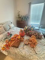 Overview of faux floral items on bed and dresser