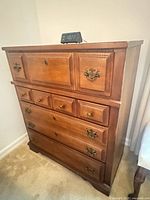 Front angled view of dresser with alarm clock on top