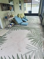 View of two outdoor rugs and cushions stacked along wall