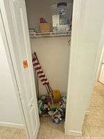 Closet view showing flag, paint supplies, level, furniture sliders, paint cans, rollers, basket and tote