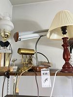 Group of four mixed-material lamps on shelf