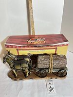 Full view of figurine on base with box and measuring stick