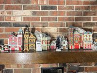 Front view of all village buildings, figurines and tree on mantel