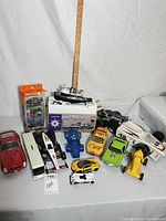 Group shot of all vehicles, boxed boat, Matchbox pack and ruler for scale