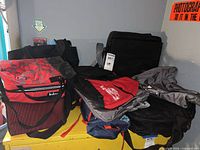 Group of seven assorted bags stacked together showing colors, brands and styles