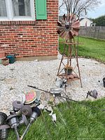 Windmill, solar lights, stepping stone, figurines and pots displayed outdoors
