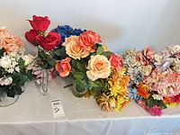 Tabletop view of mixed silk flowers and vases