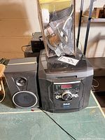 Front view of RCA stereo main unit with left speaker and assorted cables