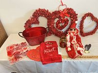 Full lot on table showing wreaths, tub, towel, doll, jar, night light, stickers, doilies