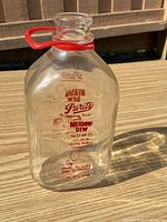 Full bottle with plastic handle showing overall form and graphics