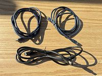 Three coiled FireWire cables laid out on wood surface