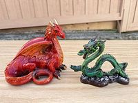 Red and green dragon figurines side by side