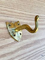 Front view of brass coat hook on shield backplate