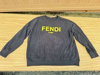 Front view of black Fendi sweatshirt with yellow FENDI ROMA print