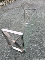 Side view showing chrome X-frame leg and glass top