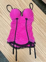 Front view of hot pink babydoll chemise showing black trim, ruffle hem, garter straps