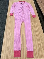 Full view of pink Lazy One union suit laid flat