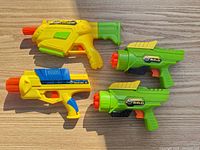 All four blasters arranged on wood surface