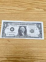 Front of enlarged laminated $1 replica showing George Washington and serial I49988499J
