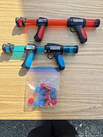 Two launchers and bag of foam balls on table