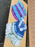 Both tie-dye tops laid flat on table