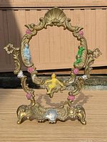 Full frontal view of ornate brass frame showing overall design, colours and size perspective