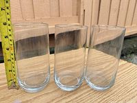 Three of the four highball tumblers with tape measure for height reference