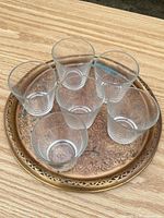 Six clear glass tumblers arranged on decorative tray