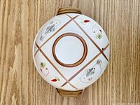 Top view of pot with lid showing hand-painted motifs and vent hole