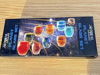 Retail box top with images of 10 planet shot glasses and Surreal Entertainment branding