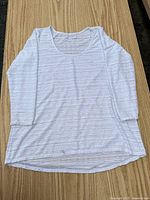 Full view of white eyelet blouse laid flat