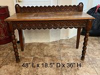 Full view of antique solid oak console table with carved gallery and turned legs