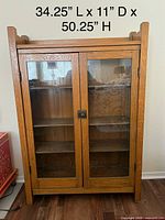 Front view of solid oak display cabinet with double glass doors