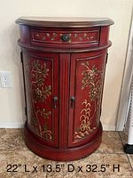 Front view of red chinoiserie cabinet showing drawer, doors, painted design, and dimensions text
