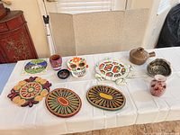 All ceramic pieces, woven trivets and glass jar displayed on table