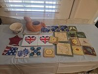 All items laid out showing bowl, planter and 16 assorted tiles/coasters