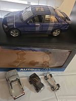 AUTOart Lexus IS300 on display base with original box and three small toy cars in foreground
