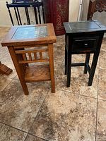Black distressed side table at right beside another table
