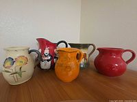 Group shot of five ceramic pitchers on table