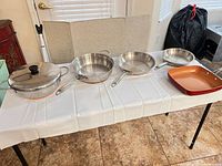 Five cookware pieces arranged on table showing overall set