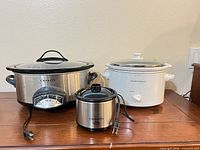 Front view of three slow cookers showing sizes and exteriors
