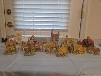 All eleven David Winter Cottages displayed on table
